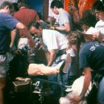 Attaching a fake leg to the camera that will quickly rush across the room. Robin Brown looks through the camera, Ted Hope looks through the list of shots left to do. 